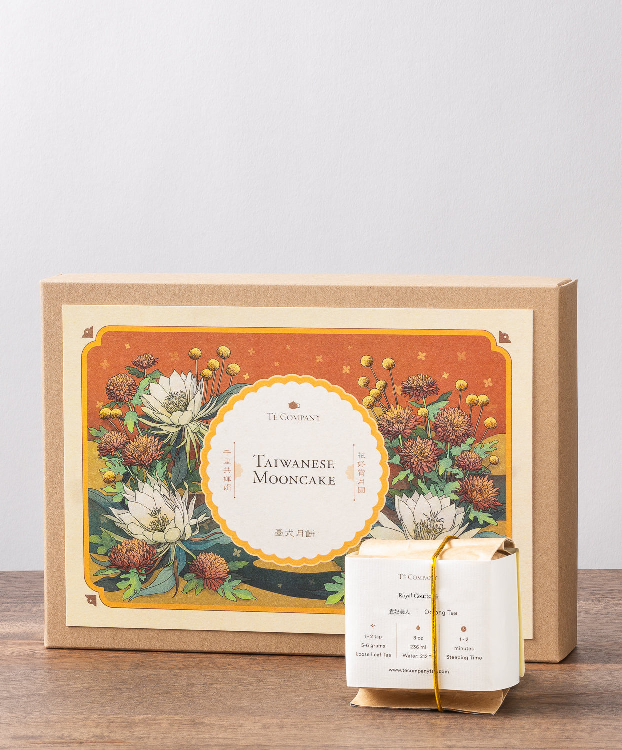 A decorative box labeled "Taiwanese Mooncake" with intricate floral illustrations, accompanied by a small wrapped tea package.