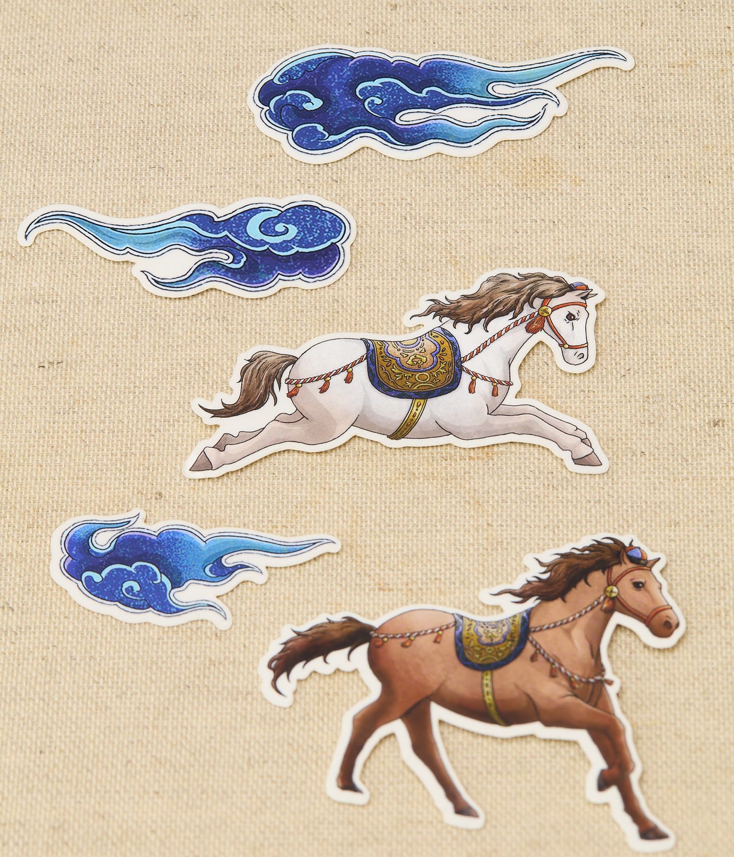 Decorative stickers of horses and clouds on a textured beige background