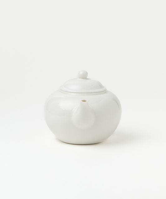Front view of a white porcelain teapot showing its spout and lid.