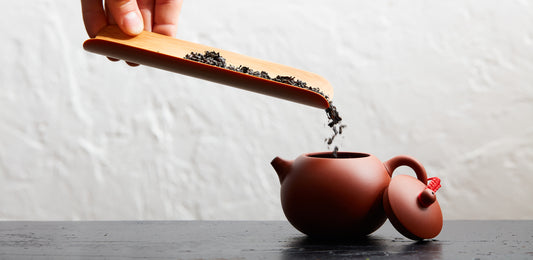 adding tea to teapot