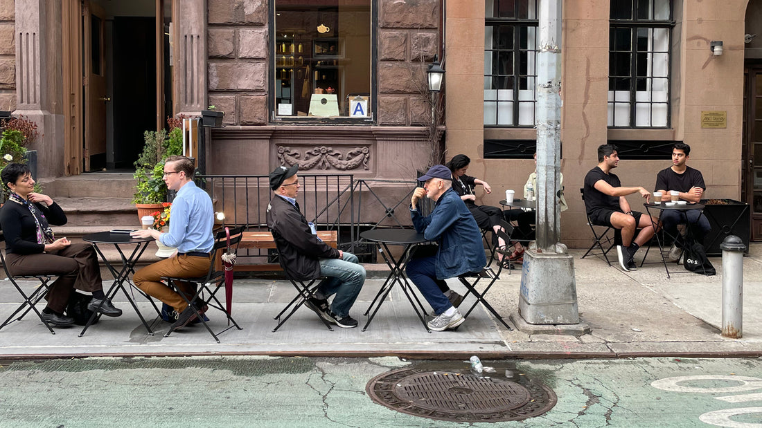 People sitting at outdoor tables in front of  Te Company.