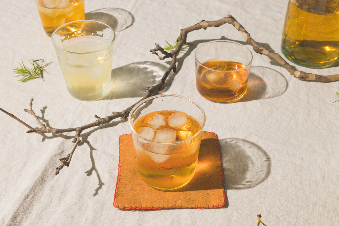 Glasses of iced tea on a table with branches.