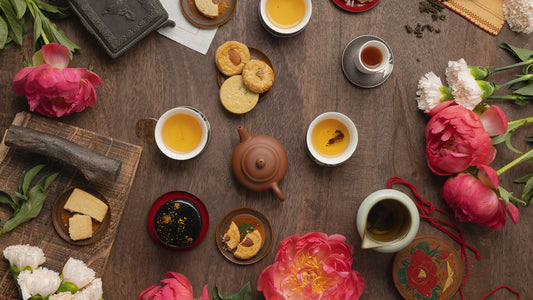 teas and tea snacks on a table with flowers