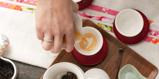 hand with tiffany ring pouring tea