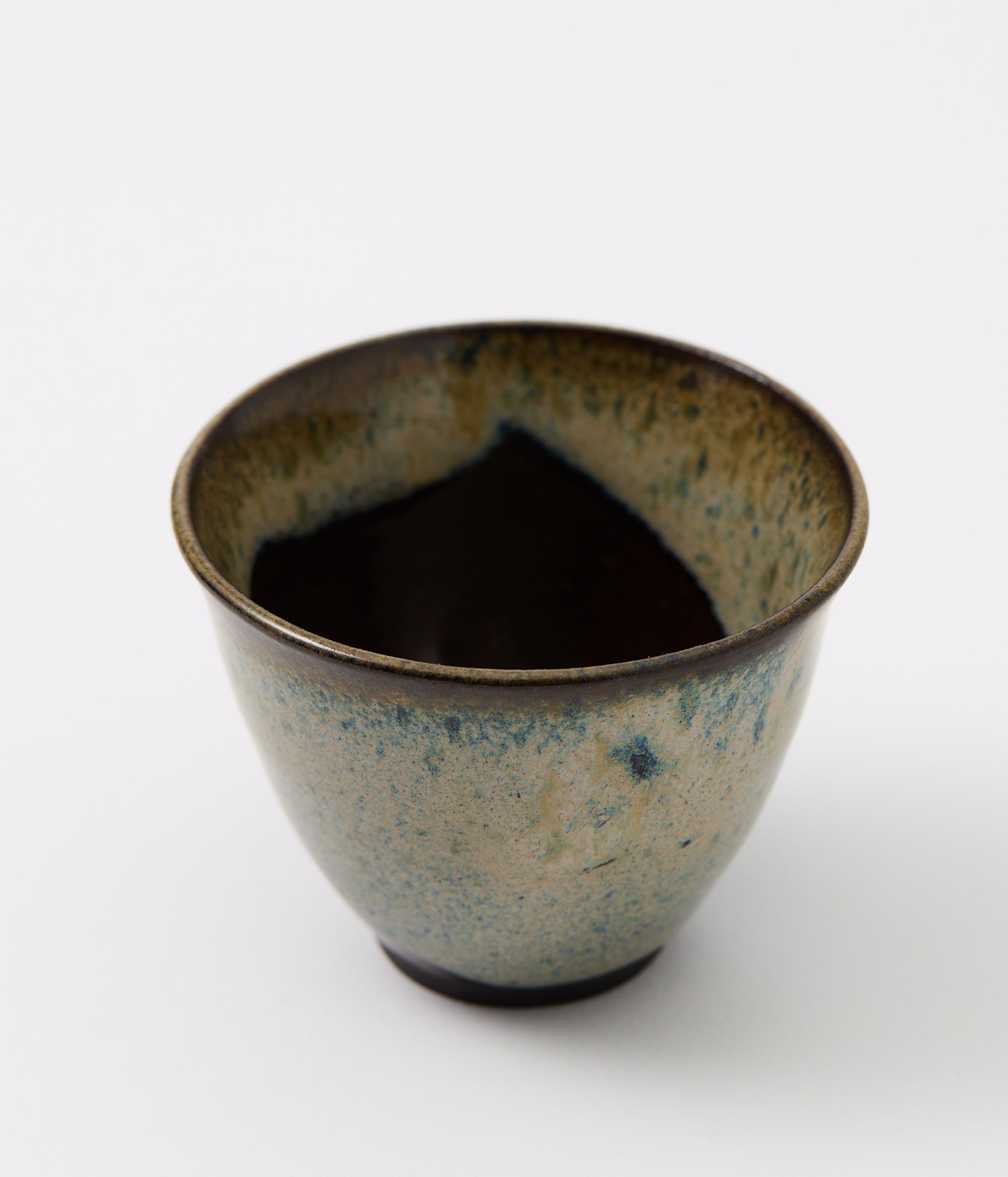 Ceramic cup with a textured surface on a white background