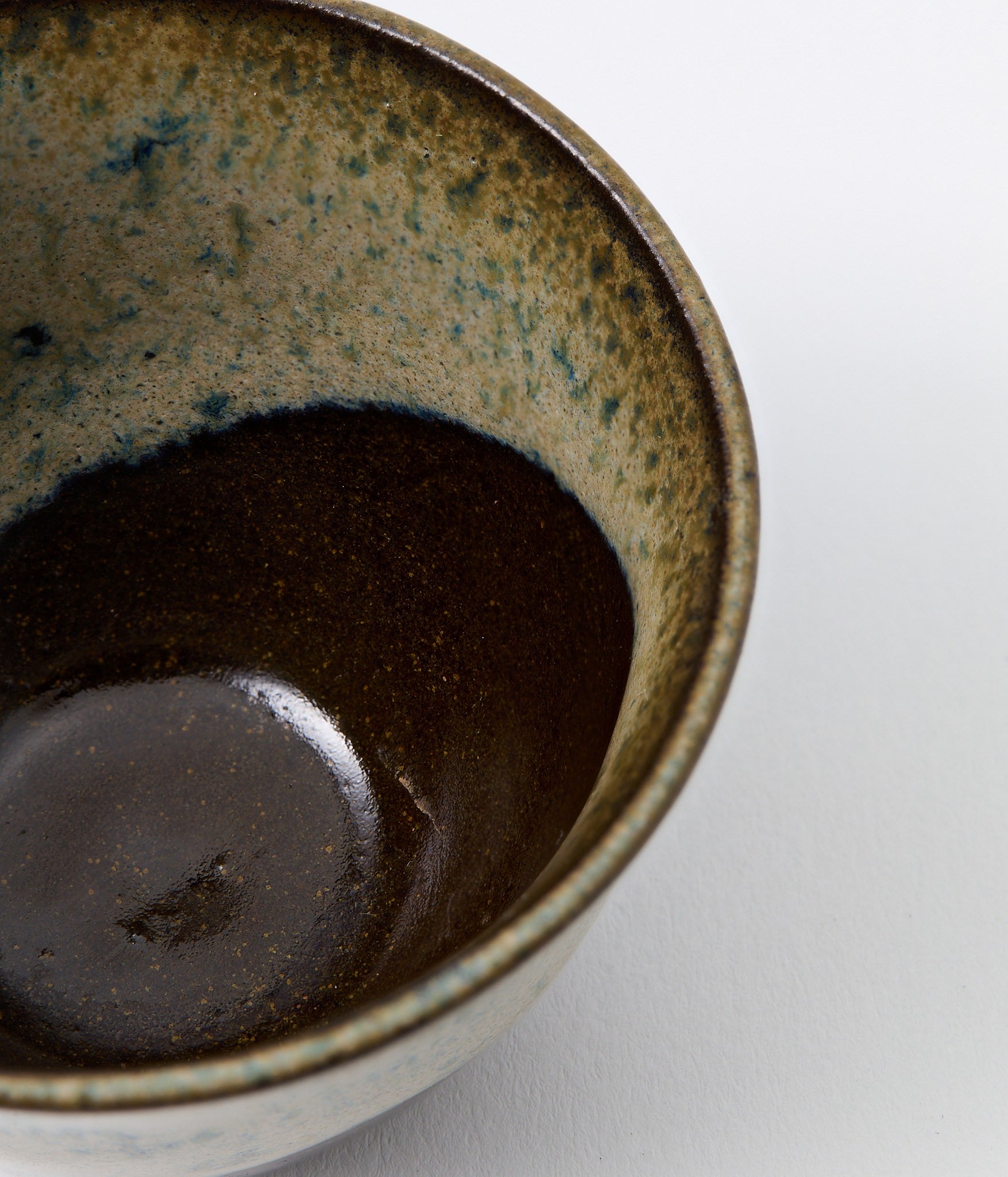 Close-up of a ceramic cup with dark liquid on a white background
