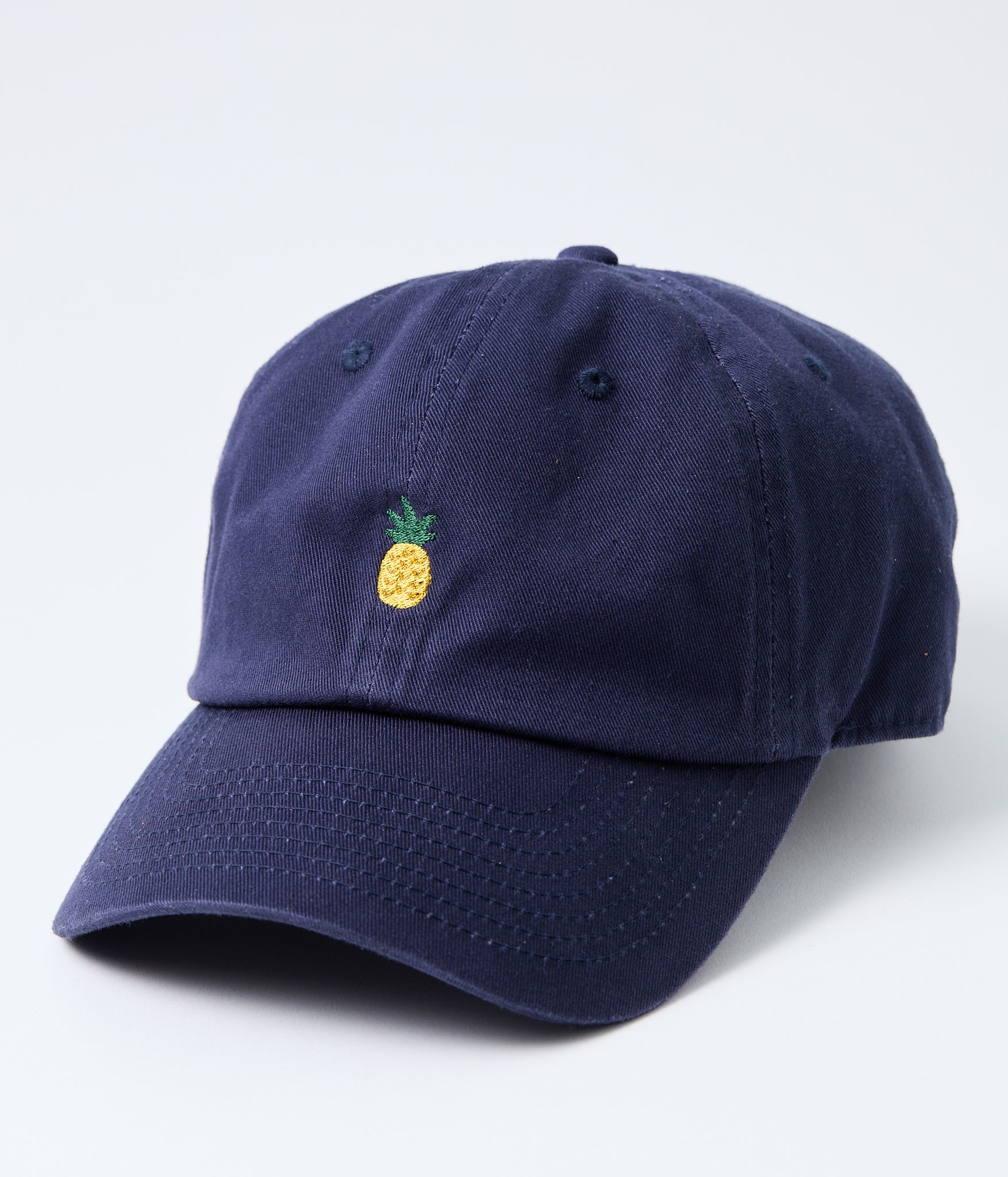 Navy blue cap with a pineapple emblem on a light gray background