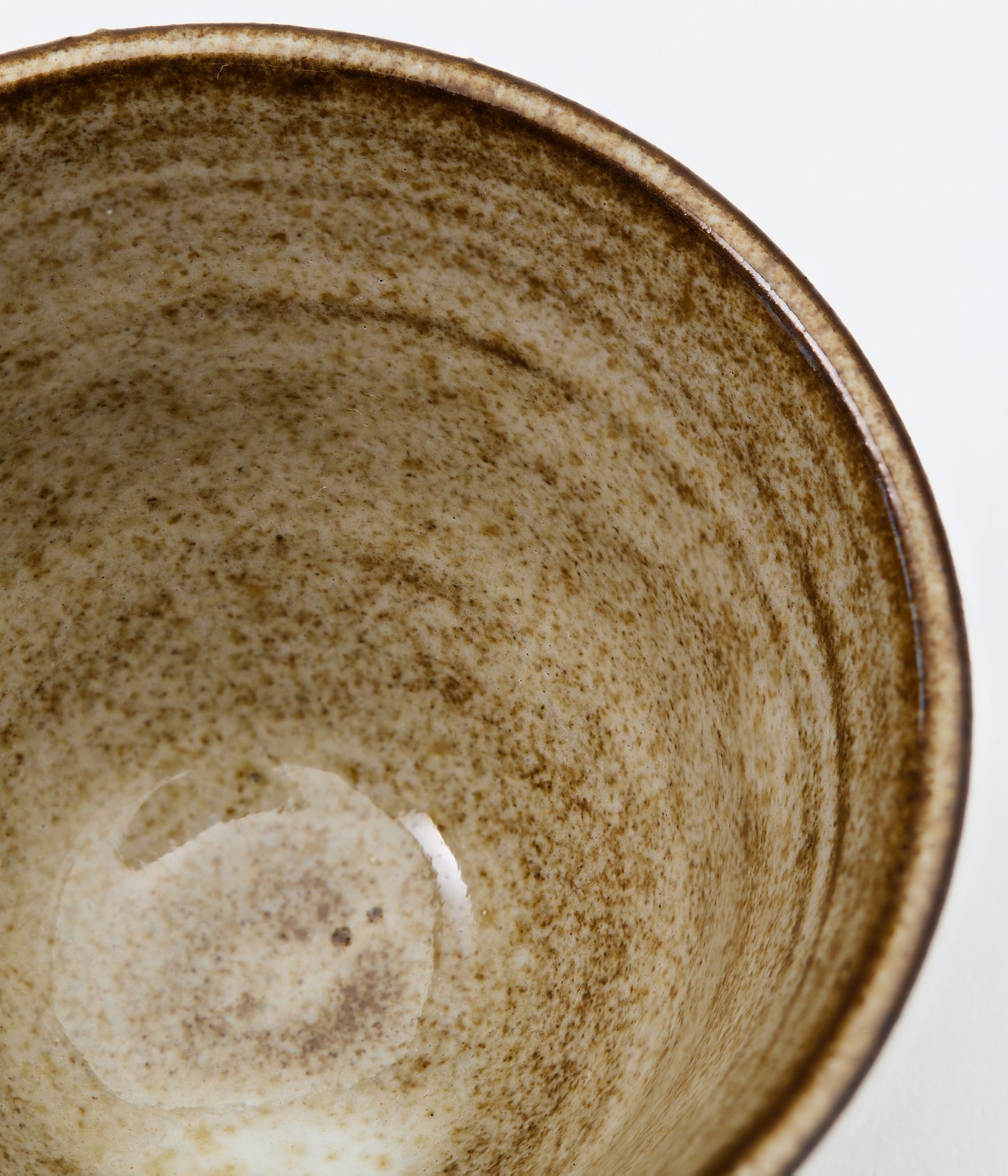 Close-up of a ceramic bowl with a textured surface on a white background