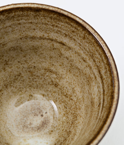 Close-up of a ceramic bowl with a textured surface on a white background