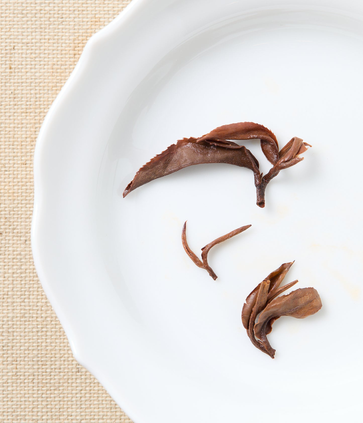 Bloomed oriental beauty tea leaves on a white plate