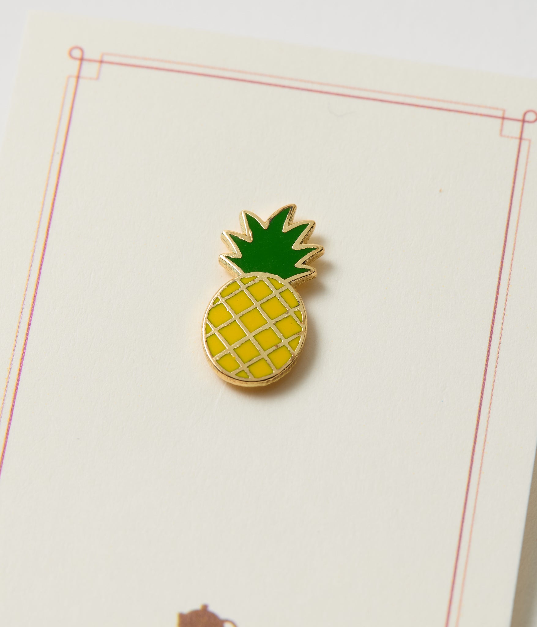Pineapple-shaped pin on a white background