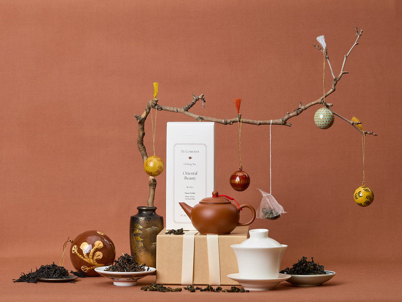 Tea-making setup with teapot, loose tea, and decorative elements on a brown background