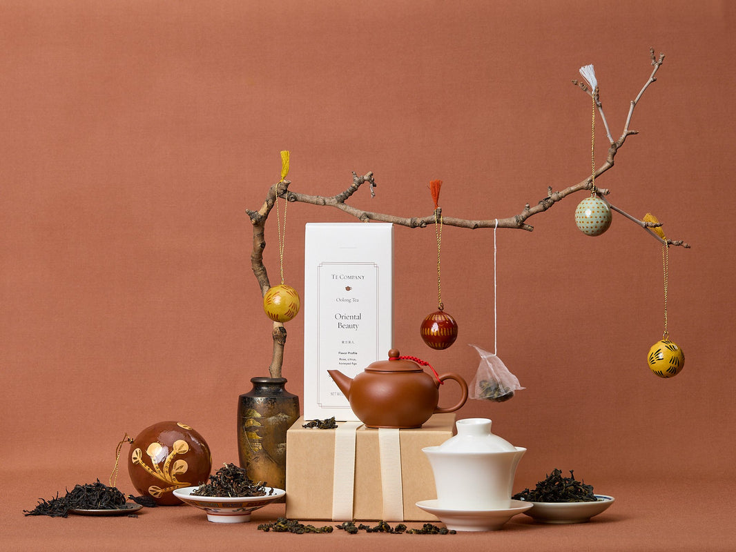 Tea-making setup with teapot, loose tea, and decorative elements on a brown background