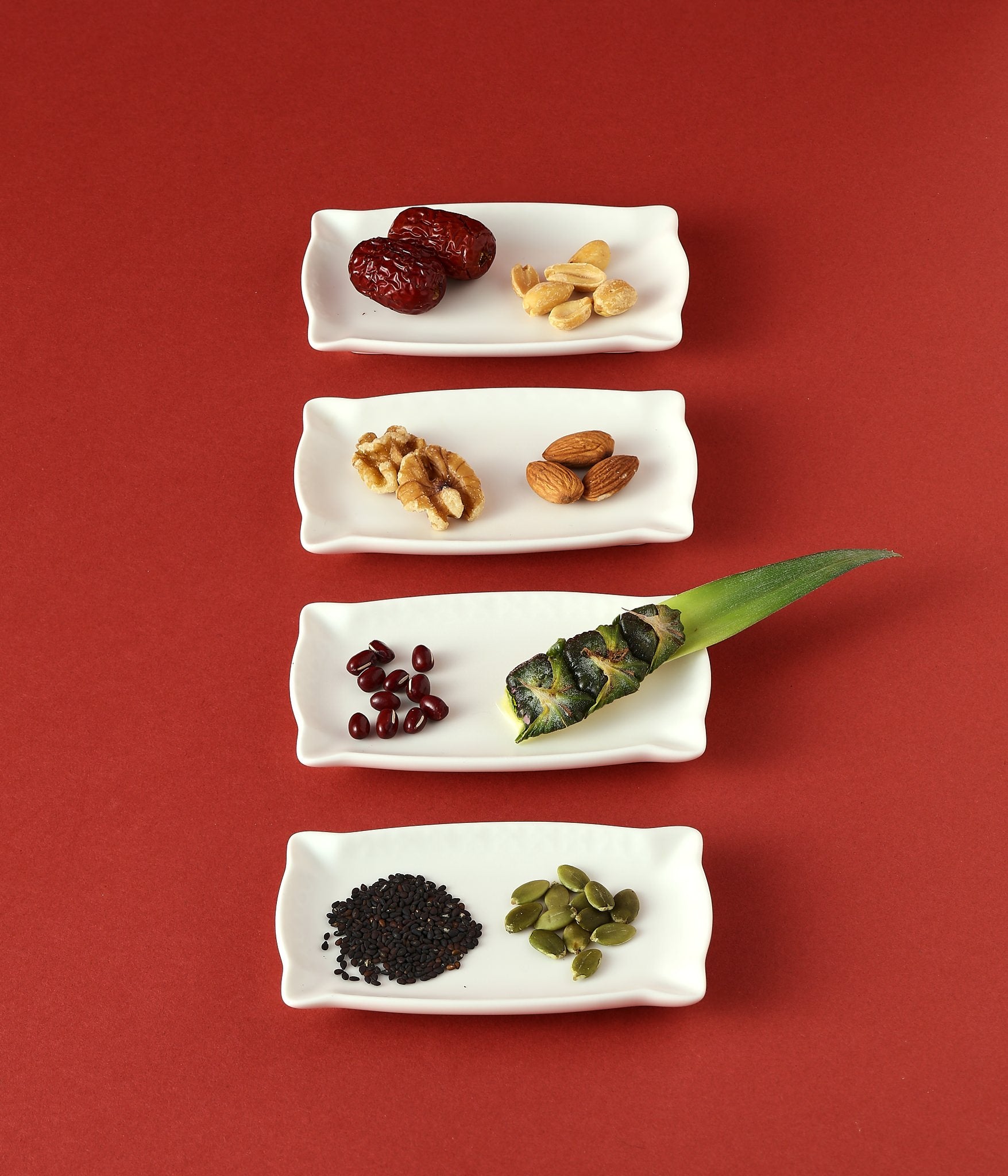 Assorted nuts, seeds, and dried fruit on white dishes