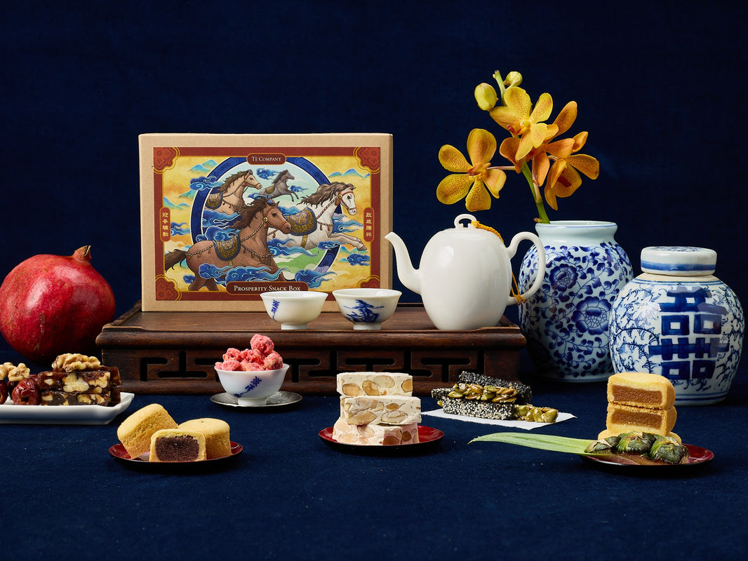 Assorted snacks, teapot, and decorative items on a dark blue background