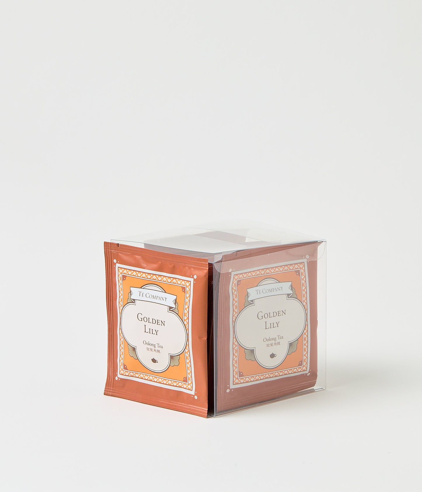 Stack of Te Company Golden Lily oolong tea packets packaged in a clear plastic box against a white background.