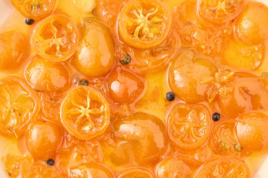 Close-up of sliced kumquats with maqaw pepper on a textured surface