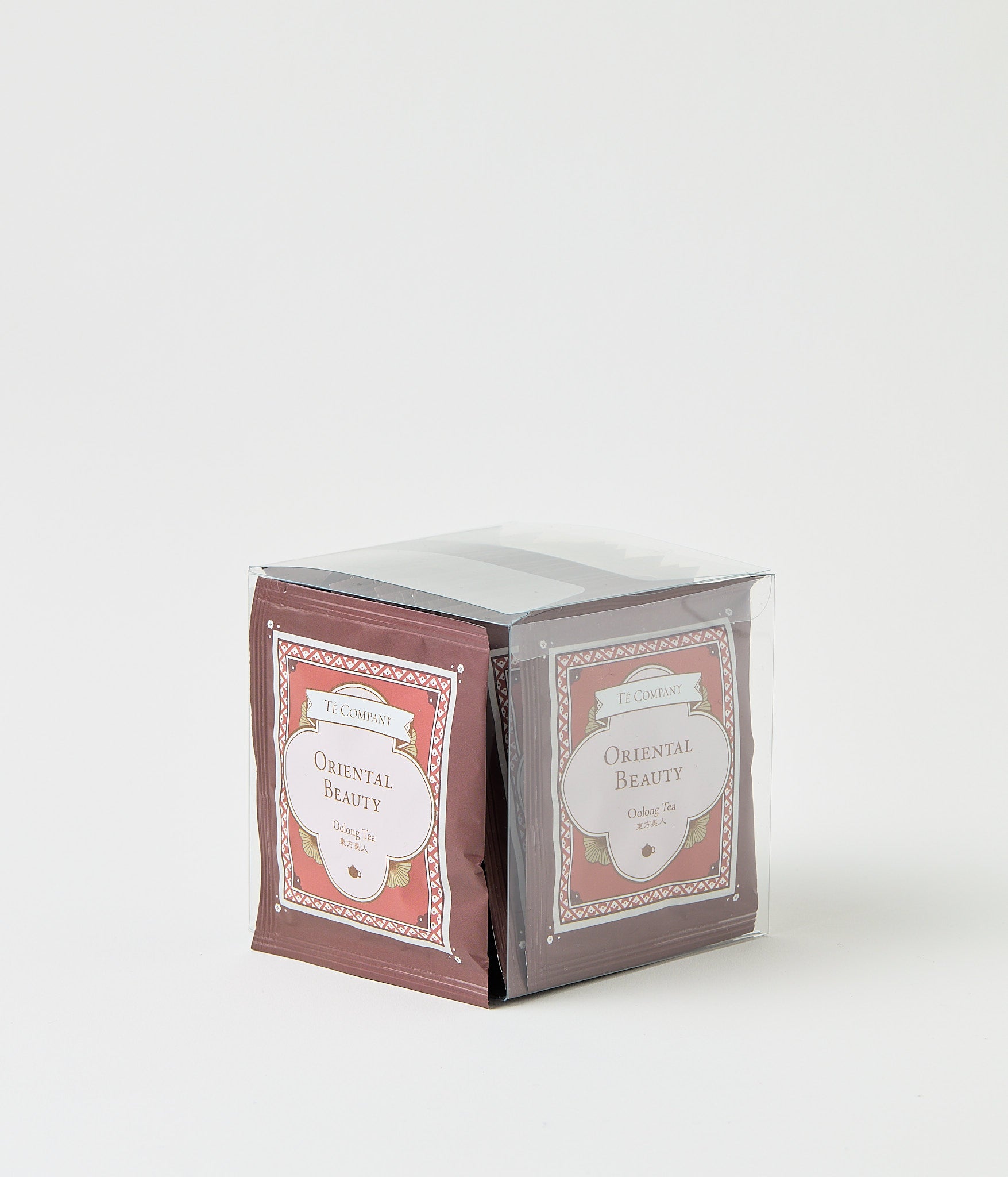 Stack of Te Company Oriental Beauty oolong tea packets packaged in a clear plastic box against a white background.