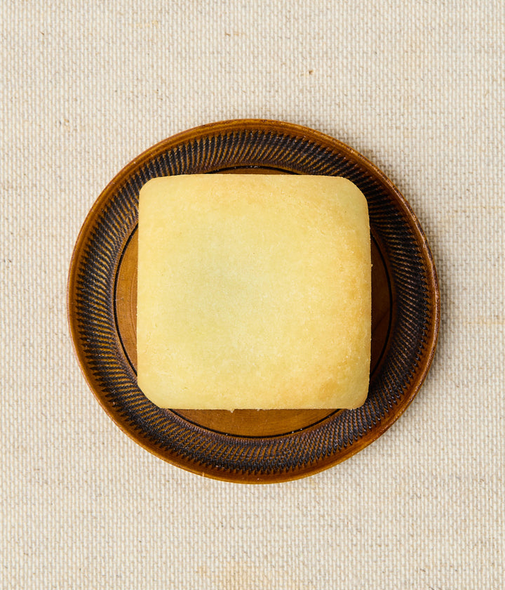 Top view of a square Taiwanese pineapple cake on a brown patterned plate.