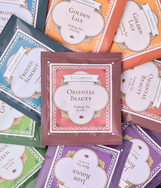 An assortment of colorful Te Company tea packets, including Oriental Beauty, Frozen Summit, Golden Lily, Formosa Green, and Jade Rouge.