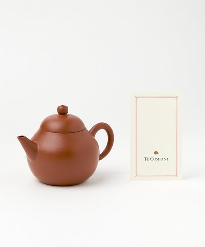 Professor Yixing Clay teapot displayed next to a Té Company card.