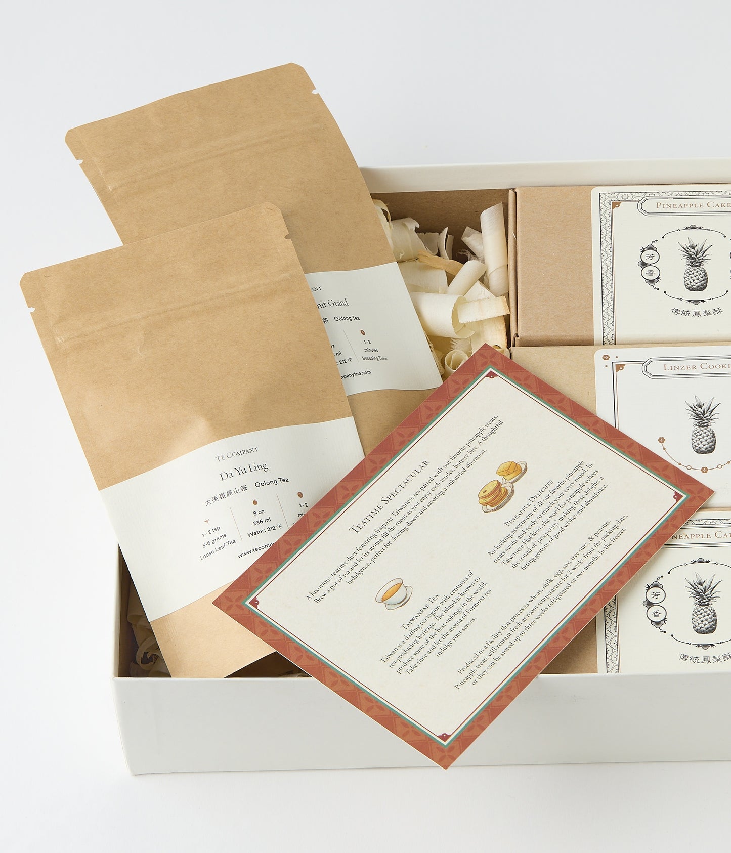 Open gift box with tea packets, pastry boxes, and printed Teatime Spectacular insert.