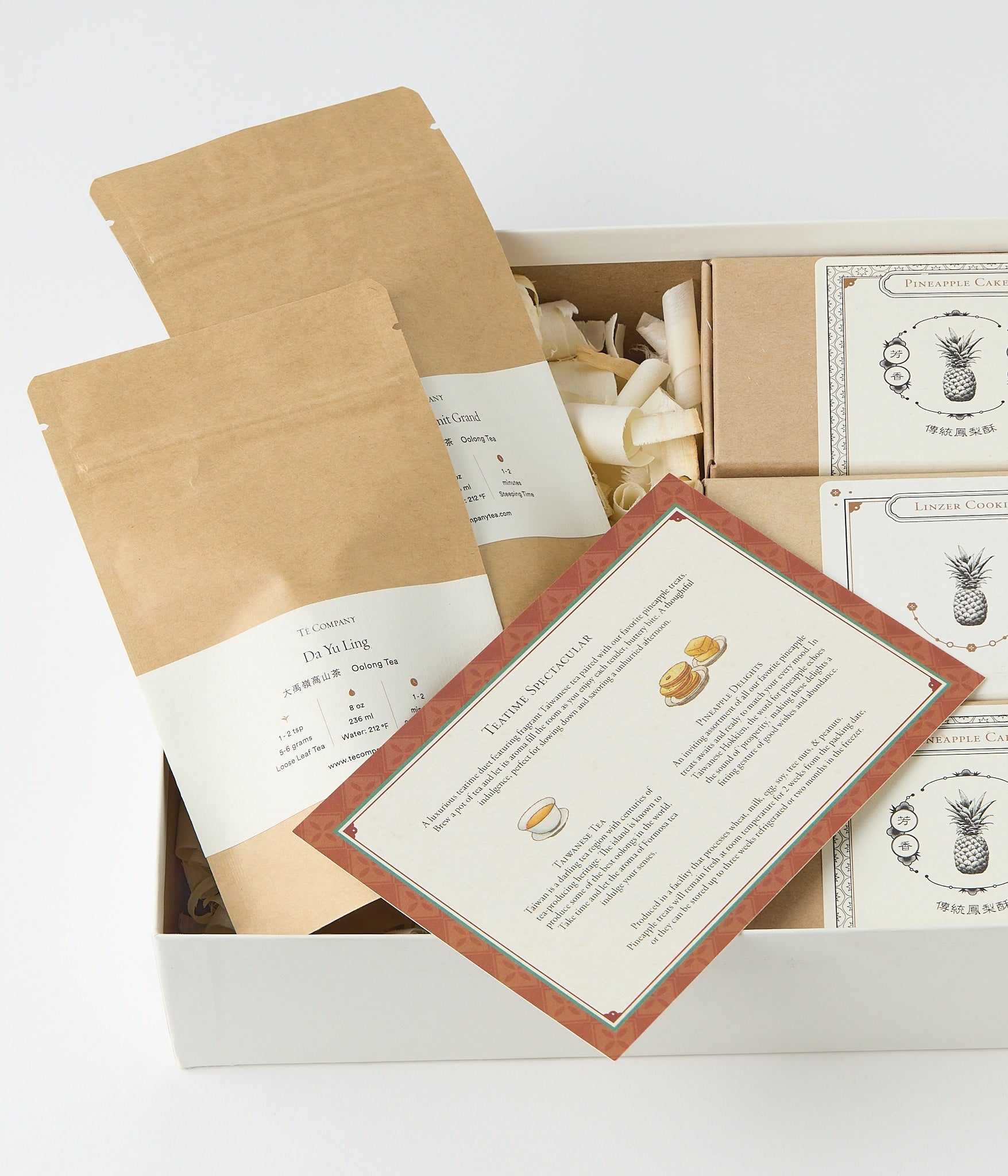 Open gift box with tea packets, pastry boxes, and printed Teatime Spectacular insert.