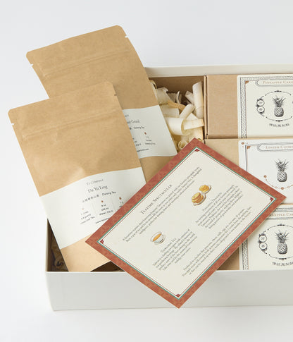 Open gift box with tea packets, pastry boxes, and printed Teatime Spectacular insert.