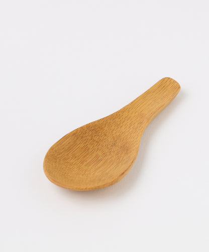 Angled view of a bamboo tea spoon showing its ergonomic handle and smooth finish.