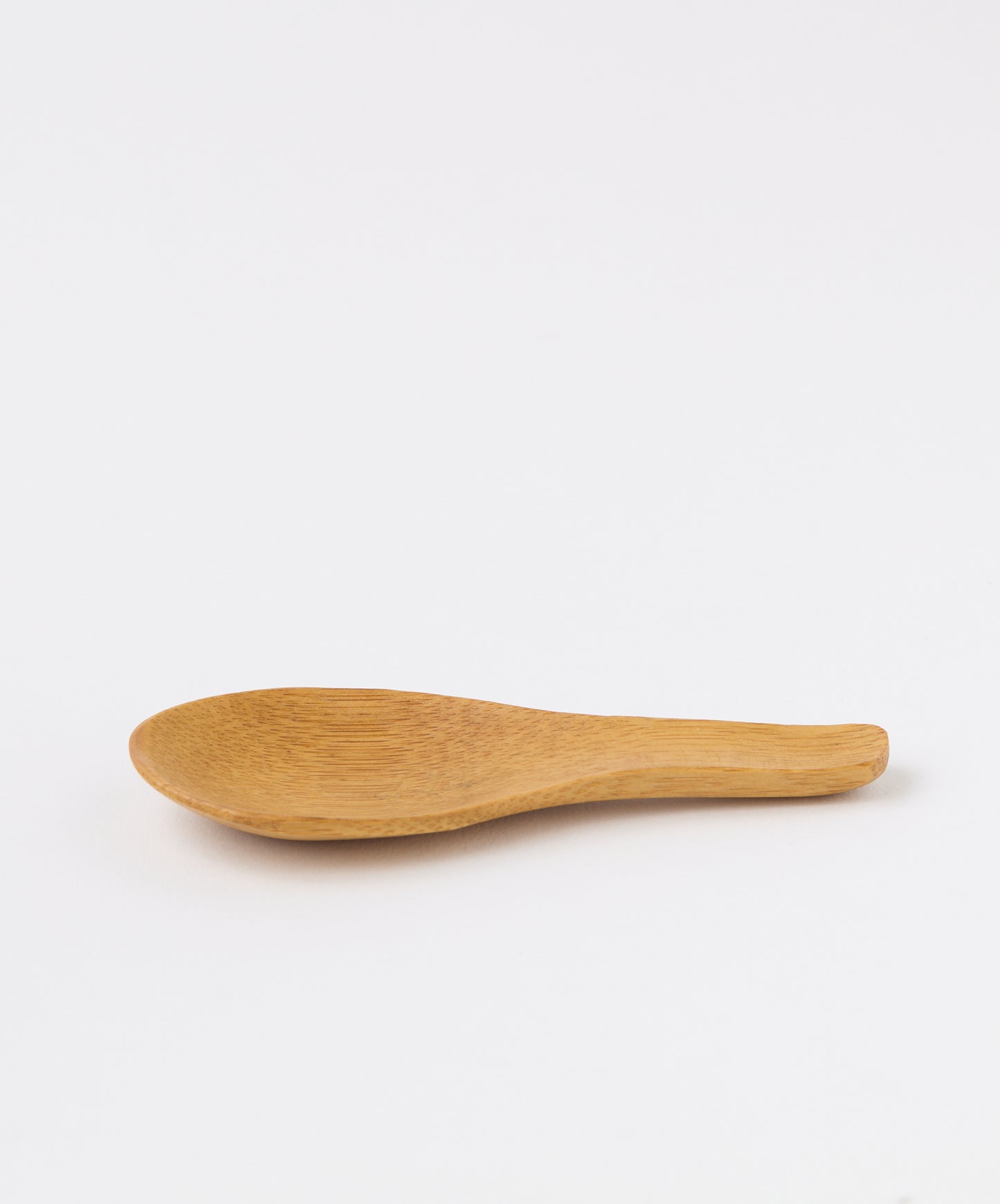 Side profile of a bamboo tea spoon highlighting its curved design.